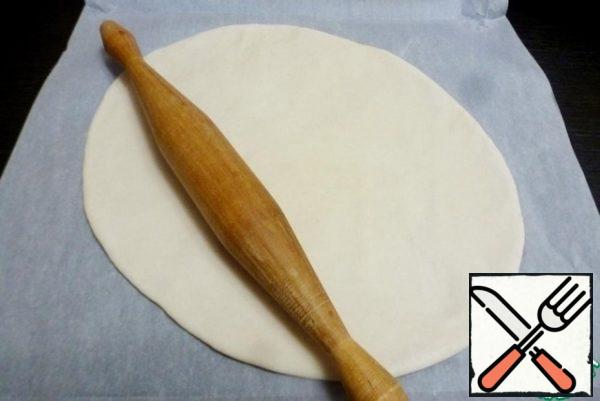 Roll out the dough into a thin tortilla, similar to pizza. I roll it out on baking paper, don't grease it with anything.
