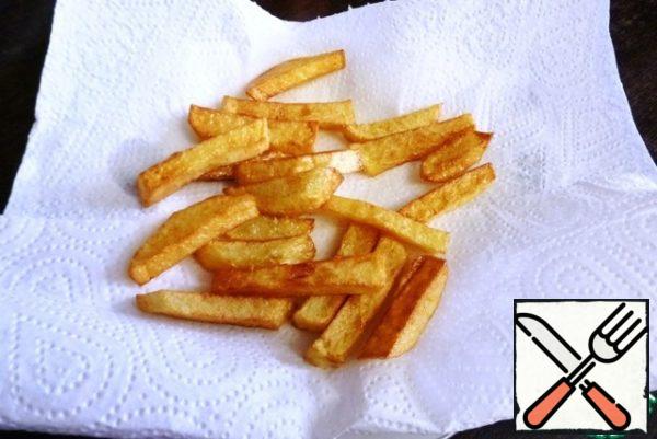 Peel the potatoes and cut them into thin slices. Fry in oil until crisp, in other words, cook French fries. Put on a napkin to get rid of excess oil.