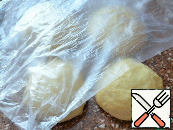 Knead the dough that comes up, divide it into 4 parts, roll it into balls, cover it. Allow 10 minutes to "rest".