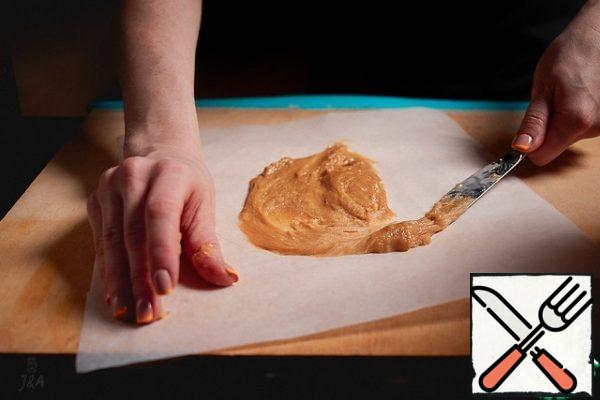 On silicone parchment from the inside draw a circle with a diameter of 18 cm. Use a wet knife to spread 1 tablespoon of dough in this frame.