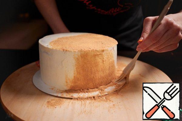 Sprinkle the crumbs on top of the cake, then brush them down the sides with a soft silicone brush.