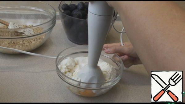 In a separate bowl, put the cottage cheese, sugar, vanilla sugar and eggs. Beat the blender into a homogeneous mass.