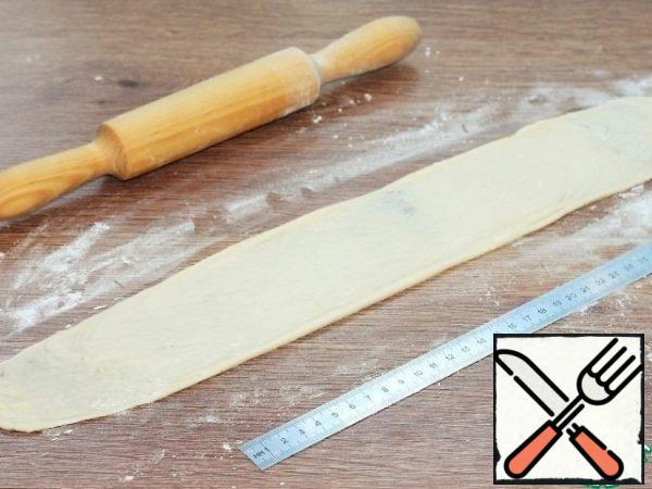 Each ball is rolled out and turned into a thin and long flat cake L=40 cm.
