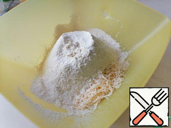 While the schnitzels are frying, mix the sifted flour, grated cheese and baking powder, add salt about 0.5-1 tsp, if the cheese is unsalted. Separately mix eggs, kefir and butter with a whisk.