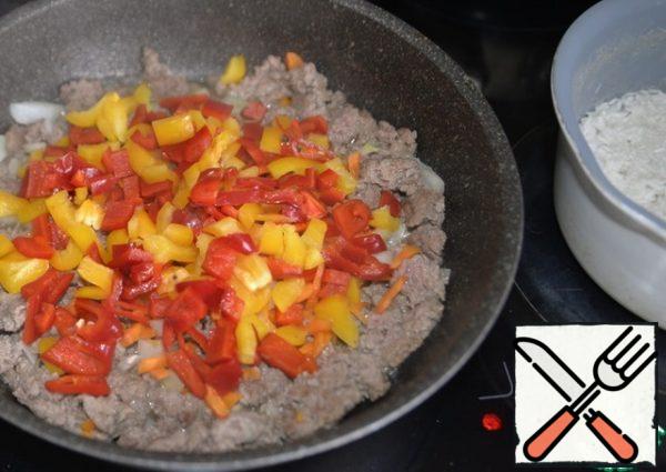 Put the pepper to the minced meat in the pan, stir, and simmer for 5 minutes.