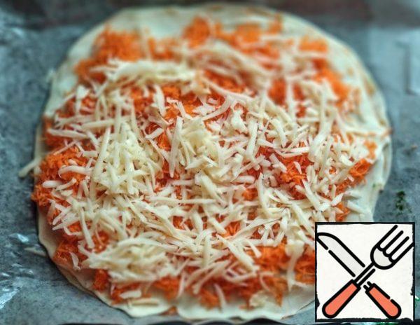 Cover with the third layer of dough. Distribute half of the carrots and cheese.