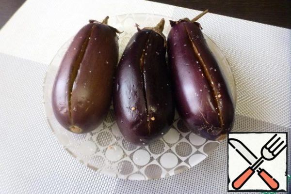 Wash and dry the eggplant, do not trim the tail. Cut the eggplant lengthwise on one side without cutting through. Inside, sprinkle with sugar, salt and leave for 30-40 minutes. During this time, the eggplant pulp will become soft and the juice will stand out. Press the pulp inside, forming a pocket.