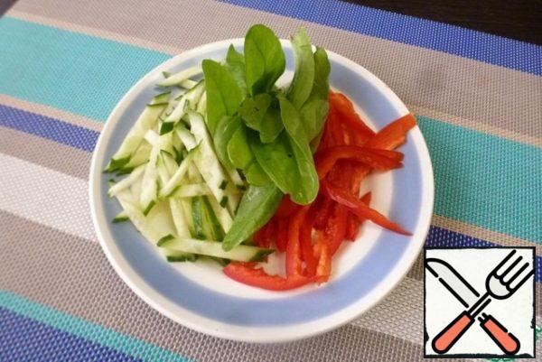 Cut fresh cucumber and sweet pepper into thin strips. Rinse the spinach with water and dry it.