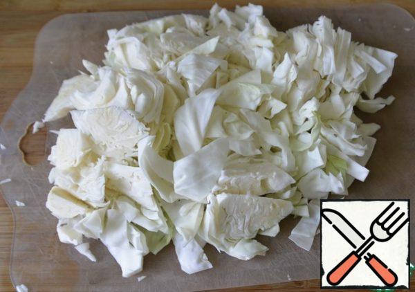 At the same time, cut the cabbage into slices, quite large, about 2 cm in size.