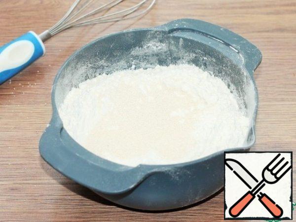 Sift flour (430 gr) and mix 4 tablespoons with dry yeast.