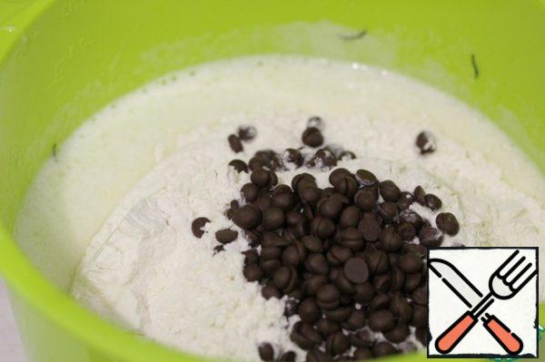 Add the flour mixed with baking powder, add the chocolate drops and mix quickly.
