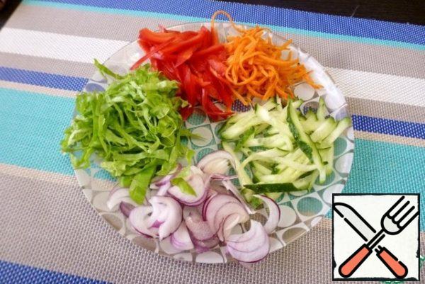 Cut fresh cucumber, sweet pepper, carrot, lettuce leaves into strips. Sweet onion cut into feathers.