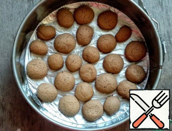 When the cookies are ready, cover the split baking dish with foil (diameter 20 cm), grease the form with vegetable oil (0.5 tbsp). spread the cookies Loosely.