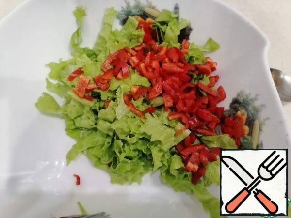 Chop the bell pepper and lettuce leaves.