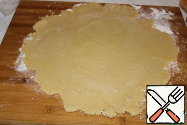Roll out the dough into a layer larger than the diameter of the mold.