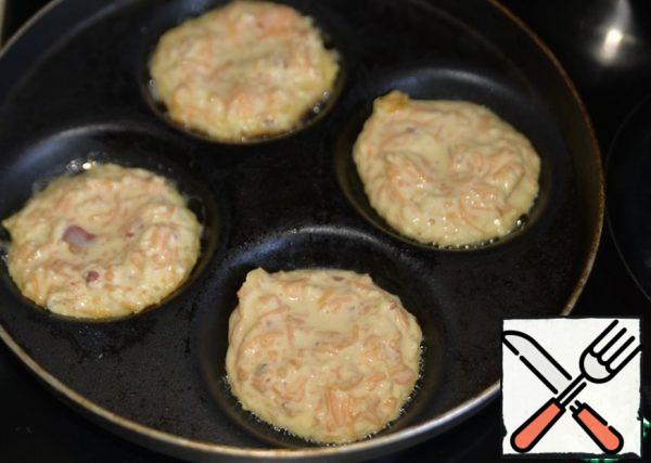 Heat the pan, I have a special one for pancakes, pour the oil. Don't pour too much oil. Spoon the dough and fry over medium heat for about 5 minutes with the lid closed.