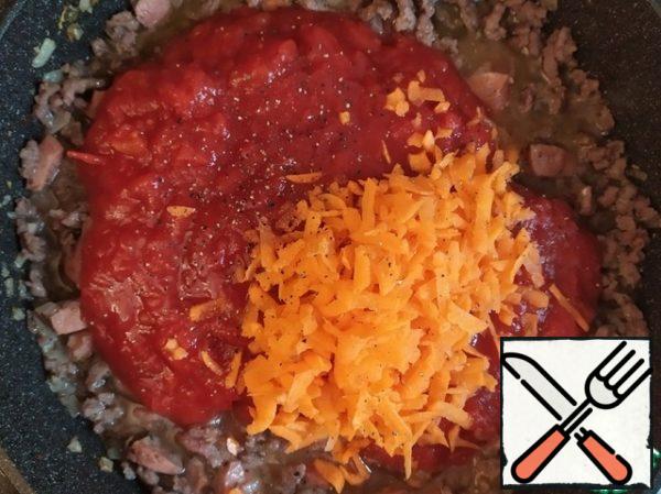 Add tomato sauce, coarsely grated carrots, you can still pepper and mix. Fry for a couple of minutes.