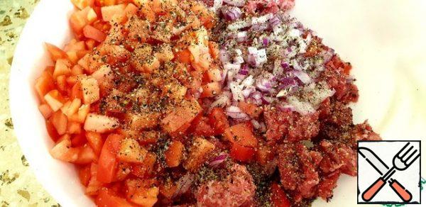 Finely chop the tomatoes and onions. Mix with minced meat. Season the minced meat with salt and pepper.