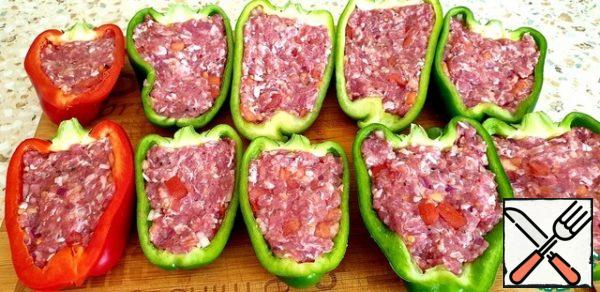 Cut the peppers in half and remove the seeds. Fill the pepper halves with minced meat.