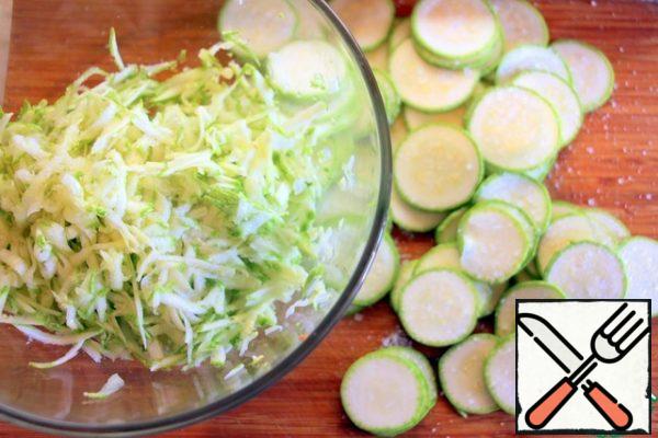 Grate more than half of the zucchini on a coarse grater, cut the rest into slices, add salt and leave for 10 minutes.