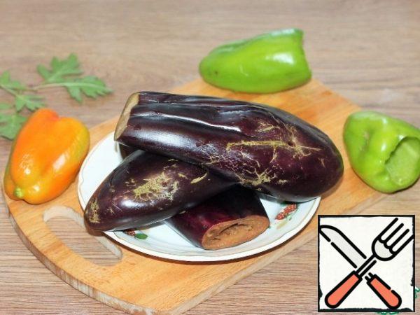 After salting, wash the eggplant. We cut off the tails of sweet pepper. Eggplant and peppers are cleaned from the seed.