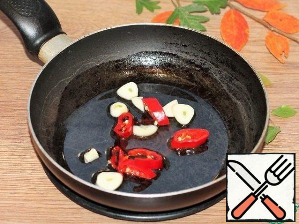 Prepare the filling. Peeled and chopped: garlic and hot pepper, fry in vegetable oil (3 tablespoons) until fragrant. Then we remove the vegetables and leave the oil.