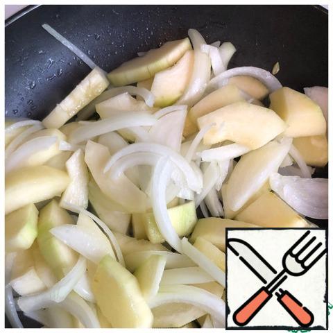 Peel the zucchini and cut it into small pieces, chop the onion into half rings. Fry the vegetables in olive oil until tender.