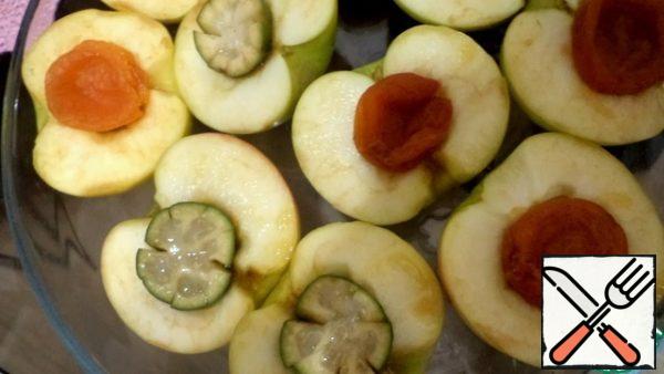 We cut the feijoa into 2 parts, make notches along the edges.  Put feijoa in the middle of half of the apples, and dried apricots in the rest.