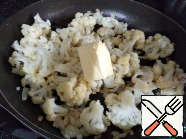 Disassemble the cabbage into inflorescences, add to the onion, put the remaining oil on top and put out 6-8 minutes under the lid.