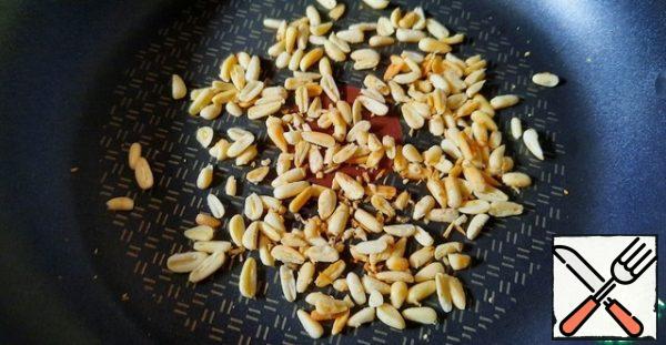Fry pine nuts in a dry pan until Golden.