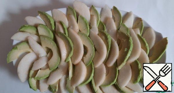 Cut the avocado and pears into thin strips and place them on a plate one at a time, drizzling the lime juice so that the fruit doesn't darken.