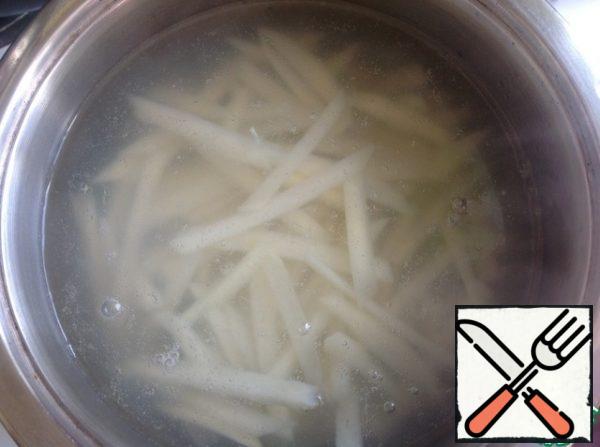 Boil the water and put the potatoes. After the water with the potatoes boils, let cook for 1 minute (no more). Put the potatoes in a colander and rinse with cold water.