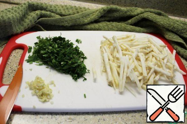 Celery root is cut into strips, garlic and herbs-finely.