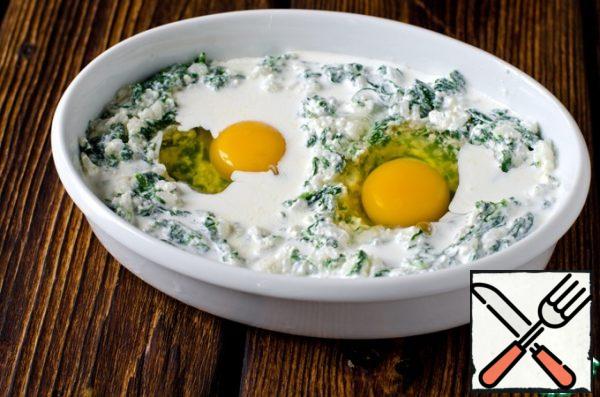 Grease the form with butter, put the spinach-rice mass in it. We make two small depressions and carefully drive the eggs into them. Pour in the remaining cream.