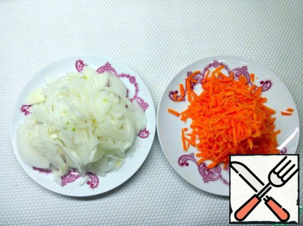 Put the rice to cook first and cook for the time indicated on the package. Peel the onion and carrot and cut the onion into half rings, and grate the carrots.