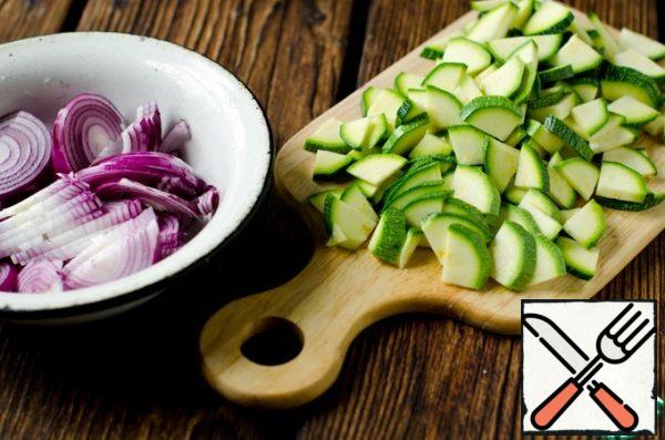 Cut the onion into half rings and the zucchini into quarters.