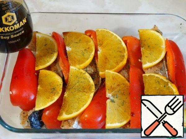 Cut the orange crosswise into thin slices and place it on the fish. On each piece of orange dripping soy sauce and sprinkle with dry dill. Bake in the oven for 15-20 minutes at medium heat.