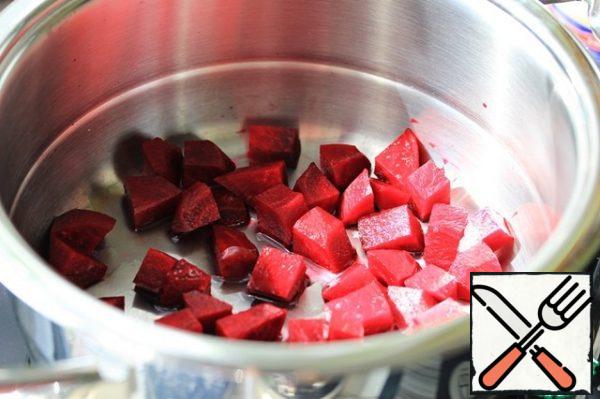 Put the beetroot slices in a saucepan, pour in 1 tablespoon of water, cover with a lid. Put the saucepan on the stove, turn on the medium heat.
When the arrow of the thermal controller reaches the green field, reduce the heat to a minimum and cook for 5 minutes.
Then remove the saucepan from the stove and leave for another 3-5 minutes, then remove the beets and cool.