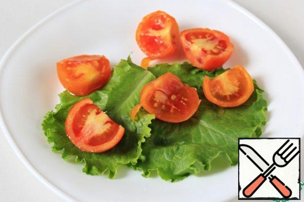Put the cherry tomatoes cut in half on a plate.