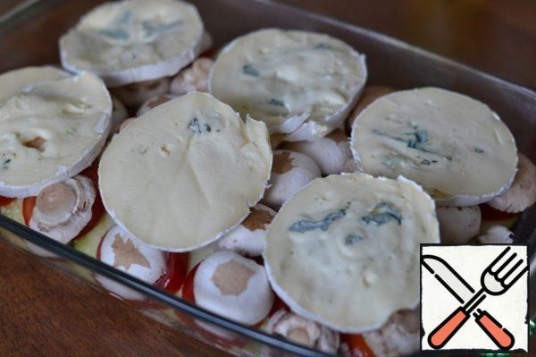 Cheese with blue mold cut into circles.
Spread on the mushrooms.