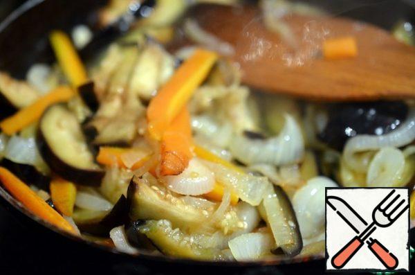 Cut the onion half-rings, carrots cut into strips. Fry them in oil for 7-10 minutes. Then add the eggplant and fry for another 5-7 minutes.