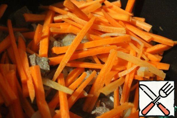 Carrots cut into strips, add to the meat. Stir and season with salt. Then we'll do a little bit together.
