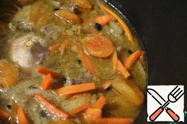 Add spices, dried apricots, whole peeled and washed garlic head and pour hot water from the kettle to cover the meat. Salt a little more. Cover with a lid and simmer on a small heat until the meat is soft.