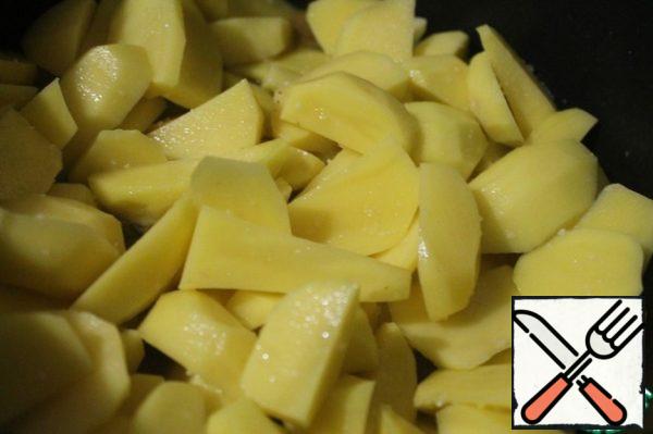Peel and slice the potatoes. Spread it on top of the meat. Cover with a lid and simmer until tender. Ready-made pilaf-style potatoes are sprinkled with chopped herbs.