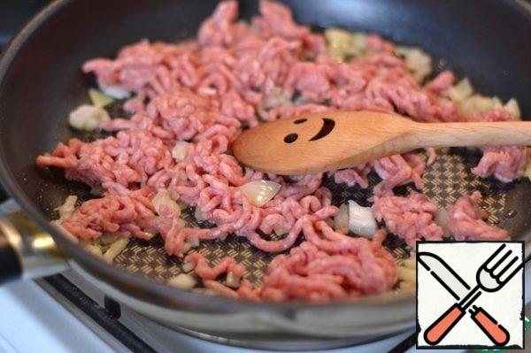 Finely chop the onion and fry it in sunflower oil.
Add the ground beef. Fry. Pepper.