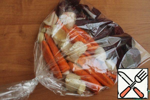 In the sleeve for baking in one layer spread the vegetables, pour the remaining sauce. Close the sleeve, make several punctures in it. Bake at 200 degrees for 20 minutes, then reduce the temperature to 180 degrees and cook for another 20 minutes.