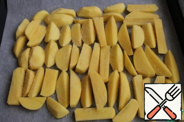 Cut the potatoes, put them on a baking sheet covered with parchment, add salt and sprinkle with breadcrumbs.