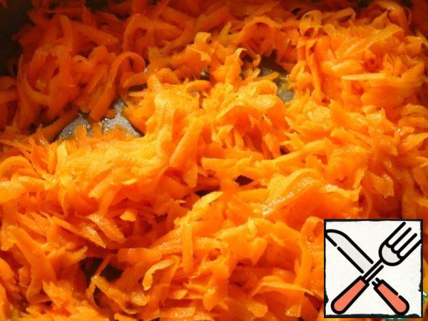Grate carrots on a coarse grater, fry in vegetable oil, stirring, 3-4 minutes.