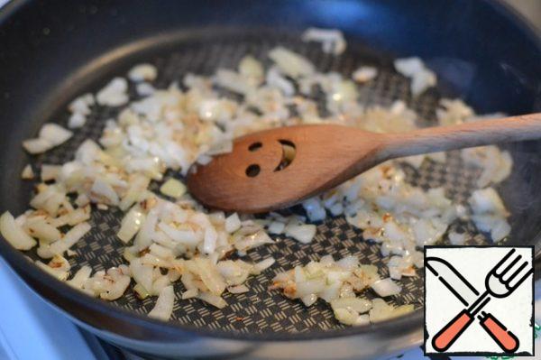 Finely chop the onion and fry it in sunflower oil.