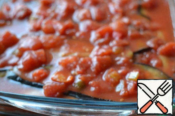 Top with 3 tablespoons of tomatoes.
Flatten with a spoon.
Lay out a layer of eggplant
Pour in the remaining tomato sauce.